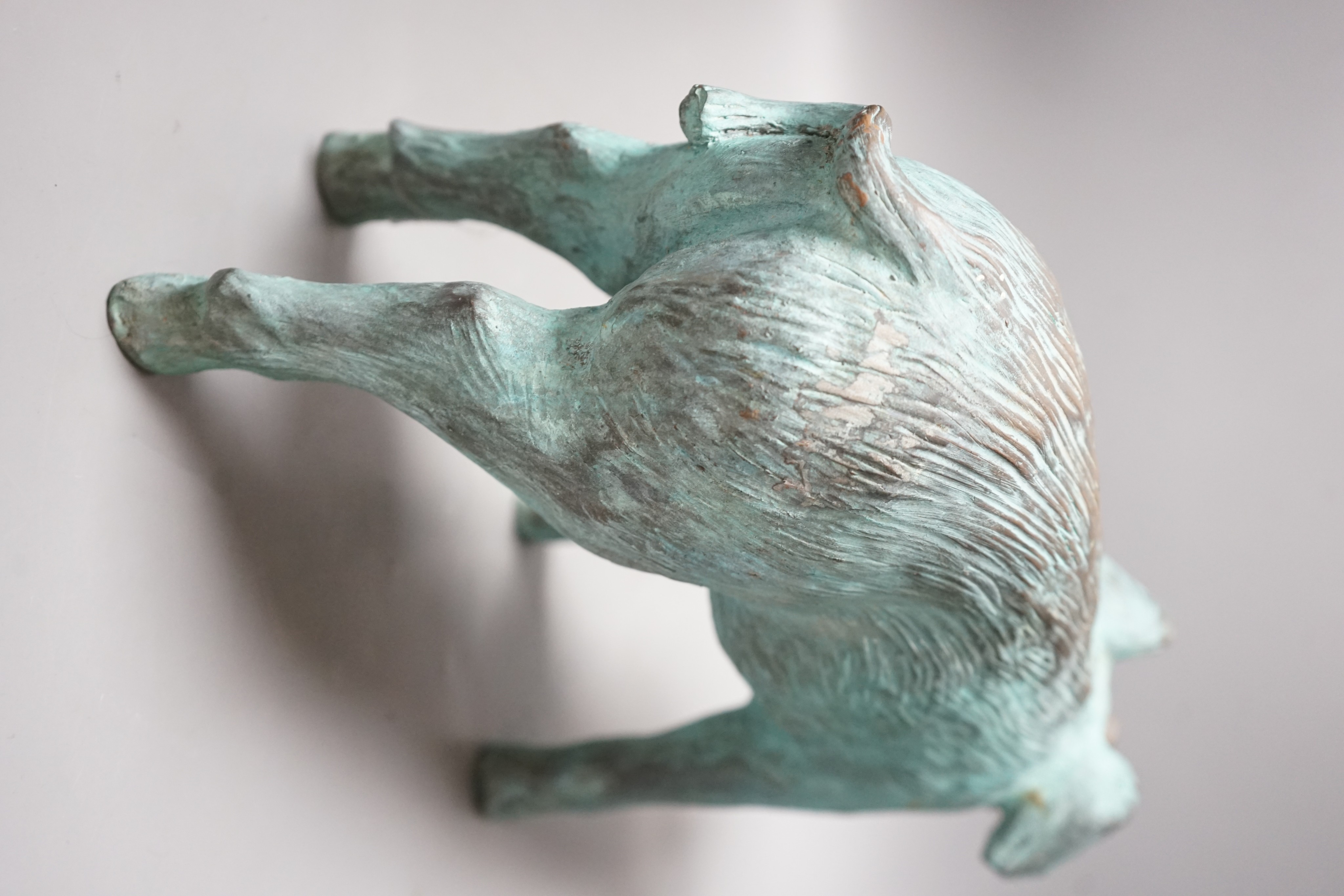 A cold cast resin bronze pig initialled 'JP', 40cm wide